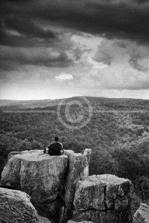 HD_STBW-44 - Lone hiker sits on one of the boulders at Chimney Rock located in Catoctin Mountain Park in Maryland HD_STBW-44 - Lone hiker sits on one of the boulders at Chimney Rock located in Catoctin Mountain Park in Maryland